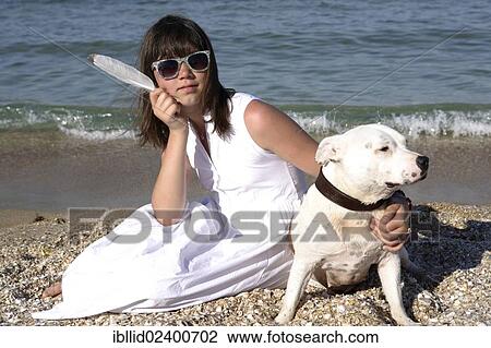 Girl sitting on the beach with a Staffordshire Bull Terrier View Large Photo Image Stock Image - Girl sitting on the beach with a Staffordshire Bull Terrier. Fotosearch