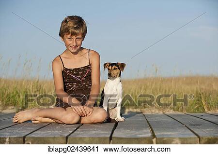 Girl sitting with a Dansk-Svensk Gardshund or Danish-Swedish Farmdog on a jetty View Large Photo Image Stock Image - Girl sitting with a Dansk-Svensk Gardshund or Danish-Swedish Farmdog on a jetty. Fotosearch