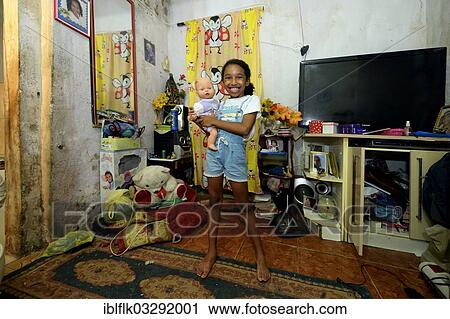 "Girl, smiling, holding a doll in an apartment in a slum or favela, Jacarezinho favela, Rio de Janeiro, Rio de Janeiro State, Brazil, South America" View Large Photo Image Stock Image - "Girl, smiling, holding a doll in an apartment in a slum or favela, Jacarezinho favela, Rio de Janeiro, Rio de Janeiro State, Brazil, South America". Fotosearch