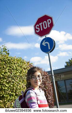 Girl standing beside a stop sign View Large Photo Image Stock Photograph - Girl standing beside a stop sign. Fotosearch