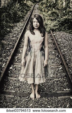 Girl standing on a railroad track View Large Photo Image Stock Image - Girl standing on a railroad track. Fotosearch