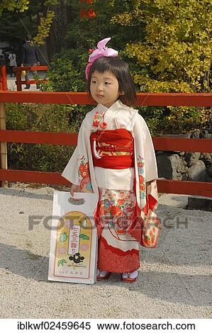 "Girl wearing a festive kimono at the Shichi-go-san festival or Seven-Five-Three festival, she is holding a typical Chitose-ame bag filled with candy canes, Shimogamo Jinja, Kyoto, Japan, East Asia, Asia" View Large Photo Image Stock Photography - "Girl wearing a festive kimono at the Shichi-go-san festival or Seven-Five-Three festival, she is holding a typical Chitose-ame bag filled with candy canes, Shimogamo Jinja, Kyoto, Japan, East Asia, Asia". Fotosearch