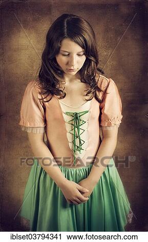 Stock Image - Girl wearing an old-fashioned dress looking sad. Fotosearch