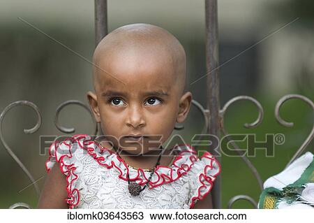 "Girl with a shaved head after making a sacrificial offering, portrait, Meenakshi Amman Temple or Sri Meenakshi Sundareswarar Temple, Madurai, Tamil Nadu, India, Asia" View Large Photo Image Stock Image - "Girl with a shaved head after making a sacrificial offering, portrait, Meenakshi Amman Temple or Sri Meenakshi Sundareswarar Temple, Madurai, Tamil Nadu, India, Asia". Fotosearch