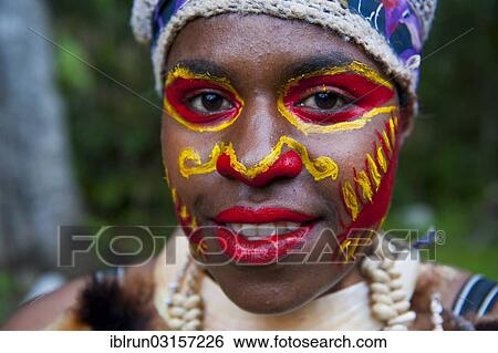 Stock Photograph - "Girl with colourful decorations and face paint is celebrating at the traditional Sing Sing gathering in the Highlands, Paya, Papua New Guinea, Oceania". Fotosearch