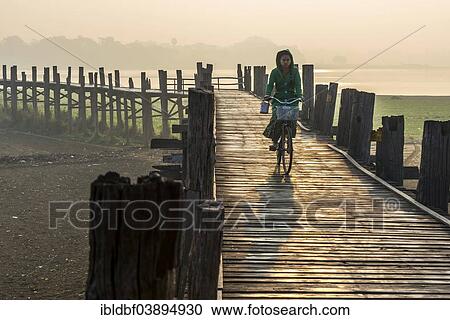 "Girl with tanaka on her face riding a bicycle on a teak bridge, U Bein Bridge over Thaungthaman Lake, Amarapura, Mandalay Division, Myanmar, Asia" View Large Photo Image Stock Image - "Girl with tanaka on her face riding a bicycle on a teak bridge, U Bein Bridge over Thaungthaman Lake, Amarapura, Mandalay Division, Myanmar, Asia". Fotosearch