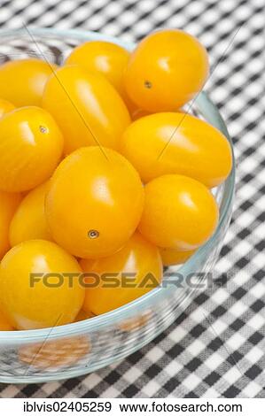 Stock Photo - Glass bowl filled with yellow plum tomatoes. Fotosearch