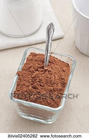 Stock Image - Glass container filled with cocoa powder. Fotosearch