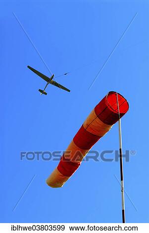 Stock Photo - "Glider at winch launching and wind sock as indicator for direction and strength of the wind, Hamburg, Germany, Europe". Fotosearch