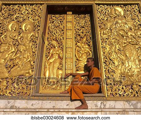 Stock Photo - "Golden reliefs, monk at the entrance to the Carriage House, Wat Xieng Tong or Vat Xienthong, Luang Prabang, Luang Prabang Province, Laos, Asia". Fotosearch