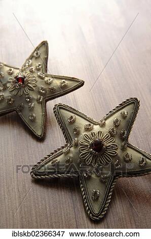 Golden textile stars on a wooden surface View Large Photo Image Stock Photo - Golden textile stars on a wooden surface. Fotosearch