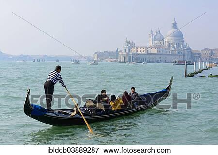 Stock Photo - "Gondolier on the Bacino San Marco, Church of Santa Maria della Salute and the Punta della Dogana at the back, Venice, Veneto, Italy, Europe". Fotosearch