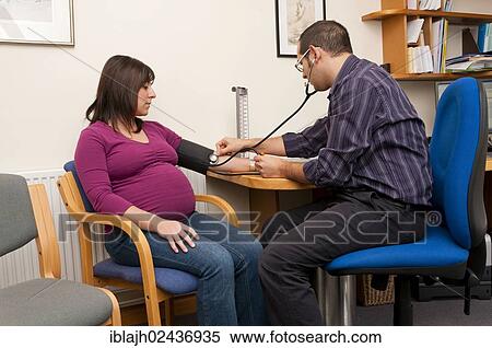 "GP doctor checking a pregnant woman's blood pressure, United Kingdom, Europe" View Large Photo Image Stock Photography - "GP doctor checking a pregnant woman's blood pressure, United Kingdom, Europe". Fotosearch