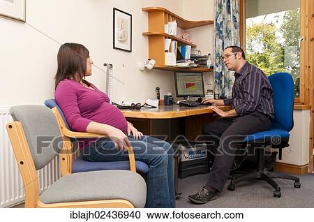 Stock Image - "GP doctor's surgery, patient consultation with a pregnant woman, United Kingdom, Europe". Fotosearch