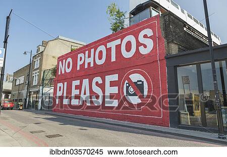 Stock Photography - "Graffiti """"No photos please"""" on a wall of the Village Underground building, Shoreditch, London, London region, England, United Kingdom, Europe". Fotosearch