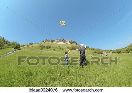 "Grandfather and grandson flying a kite, Crimean Mountains, Crimea, Ukraine, Europe" View Large Photo Image Stock Image - "Grandfather and grandson flying a kite, Crimean Mountains, Crimea, Ukraine, Europe". Fotosearch