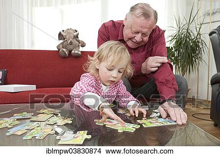 "Grandfather and his granddaughter, 3 years, working on a jigsaw puzzle" View Large Photo Image Picture - "Grandfather and his granddaughter, 3 years, working on a jigsaw puzzle". Fotosearch