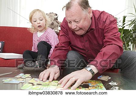 "Grandfather and his granddaughter, 3 years, working on a jigsaw puzzle" View Large Photo Image Stock Photo - "Grandfather and his granddaughter, 3 years, working on a jigsaw puzzle". Fotosearch
