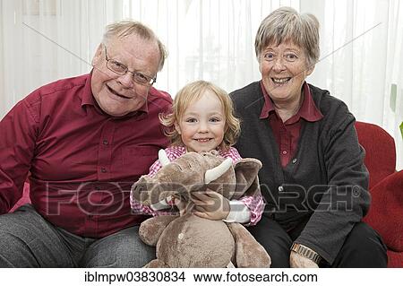 "Grandparents with their granddaughter, 3 years, holding a soft toy" View Large Photo Image Picture - "Grandparents with their granddaughter, 3 years, holding a soft toy". Fotosearch