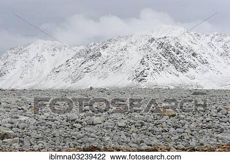 Stock Image - "Gravel field in front of a snow-covered summit ridge, Magdalenefjorden, Spitsbergen Island, Svalbard Archipelago, Svalbard and Jan Mayen, Norway, Europe". Fotosearch