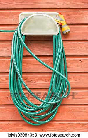 "Green plastic garden hose and nozzle hanging on the wall of a red wooden house, Stockholm, Stockholm County, Sweden, Europe" View Large Photo Image Stock Image - "Green plastic garden hose and nozzle hanging on the wall of a red wooden house, Stockholm, Stockholm County, Sweden, Europe". Fotosearch