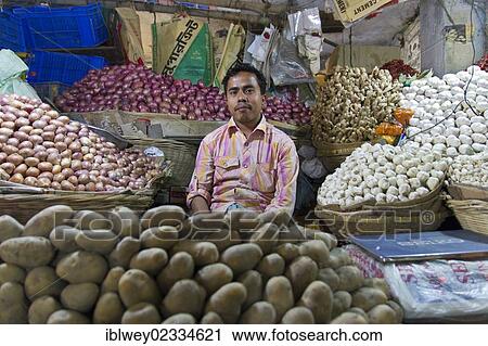 "Greengrocer seated between baskets of potatoes, onions, garlic and ginger, New Market, Dhaka, Bangladesh, South Asia, Asia" View Large Photo Image Stock Image - "Greengrocer seated between baskets of potatoes, onions, garlic and ginger, New Market, Dhaka, Bangladesh, South Asia, Asia". Fotosearch