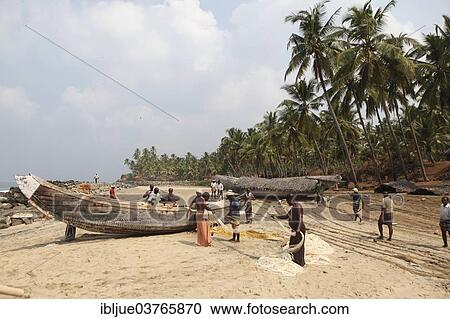 Stock Image - "Group of fishermen sorting their nets on the beach, Varkala, Kerala, India, Asia". Fotosearch