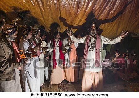 Stock Image - "Group of Jangam Sadhus, holy men, singing a song for another sadhu in his tent at the Sangam, the confluence of the rivers Ganges, Yamuna and Saraswati, during Kumbha Mela festival, Allahabad, Uttar Pradesh, India, Asia". Fotosearch