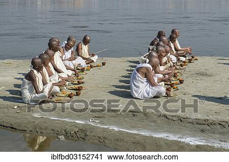 Stock Image - "Group of new Jain nuns sitting at the banks of the river Ganges during their initiation, during Kumbha Mela festival, Allahabad, Uttar Pradesh, India, Asia". Fotosearch