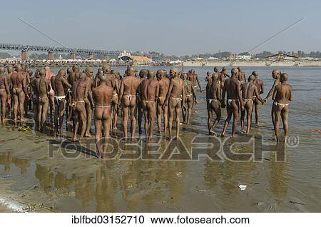 Stock Image - "Group of new sadhus standing in the river Ganges, as part of their initiation, during Kumbha Mela festival, Allahabad, Uttar Pradesh, India, Asia". Fotosearch