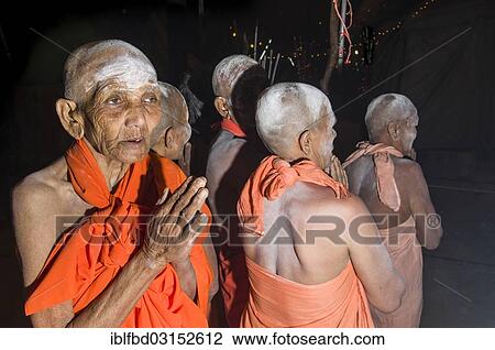 Stock Image - "Group of newly initiated Shiva sadhvis, holy women, from Avan Akhara, praying at night at the Sangam, the confluence of the rivers Ganges, Yamuna and Saraswati, during Kumbha Mela festival, Allahabad, Uttar Pradesh, India, Asia". Fotosearch