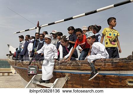 Stock Photograph - "Group of Omani school children playing on an old dhow-ship, Dhow Museum, Sur, Ash Sharqiyah province, Sultanate of Oman, Arabian Peninsula". Fotosearch