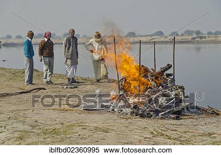 Stock Photography - "Group of people watching the cremation ceremony of a family member on the banks of river Yamuna, Vrindavan, India, Asia". Fotosearch