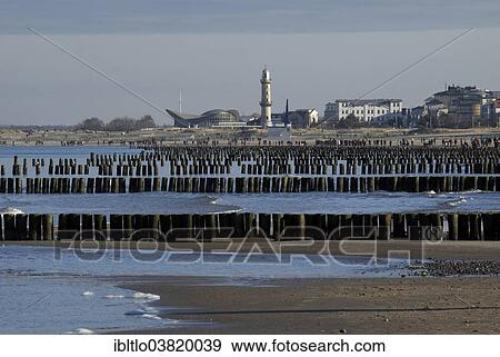 "Groynes on the beach of Warnemunde, """"Teepott"""" or """"Tea Pot"""" building and lighthouse, Warnemunde, Rostock, Mecklenburg-Vorpommern, Germany, Europe" View Large Photo Image Stock Photo - "Groynes on the beach of Warnemunde, """"Teepott"""" or """"Tea Pot"""" building and lighthouse, Warnemunde, Rostock, Mecklenburg-Vorpommern, Germany, Europe". Fotosearch