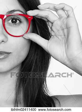 Stock Image - Half portrait of a young woman in black and white with red glasses. Fotosearch