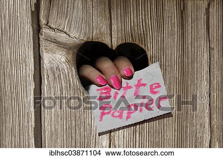"Hand holding a note, """"Bitte Papier"""", German for """"Paper please"""", through the heart-shaped hole of a toilet house" View Large Photo Image Picture - "Hand holding a note, """"Bitte Papier"""", German for """"Paper please"""", through the heart-shaped hole of a toilet house". Fotosearch