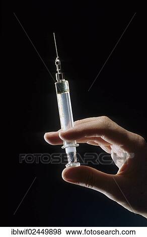 Hand holding syringe View Large Photo Image Stock Photo - Hand holding syringe. Fotosearch