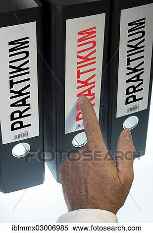 Stock Photography - "Hand pointing to a file folder labeled """"Praktikum"""", German for """"internship""""". Fotosearch