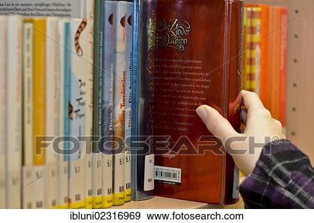 Stock Photo - Hand pulling a book from a library shelf. Fotosearch