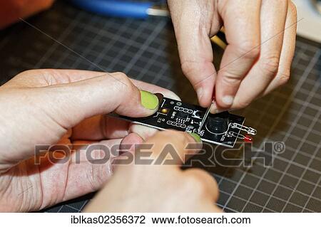 "Hand with painted nails and a child's hand working together on an electronic device with light emitting diodes, IdeenPark 2012, technology and education summit conference for young people, Essen, Ruhr area, North Rhine-Westphalia, Germany, Europe" View Large Photo Image Stock Image - "Hand with painted nails and a child's hand working together on an electronic device with light emitting diodes, IdeenPark 2012, technology and education summit conference for young people, Essen, Ruhr area, North Rhine-Westphalia, Germany, Europe". Fotosearch