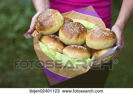 Stock Image - Hands holding a basket full of burger buns. Fotosearch