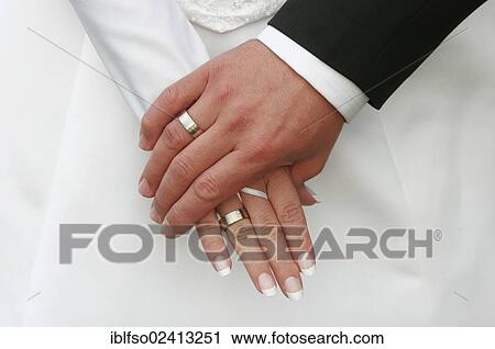Stock Image - Hands of a bride and groom. Fotosearch