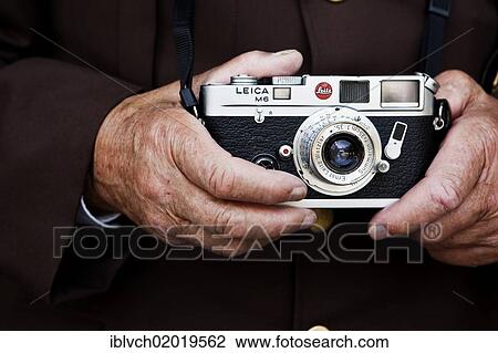 "Hands of an elderly man holding a Leica rangefinder camera, North Tyrol, Austria, Europe" View Large Photo Image Stock Image - "Hands of an elderly man holding a Leica rangefinder camera, North Tyrol, Austria, Europe". Fotosearch