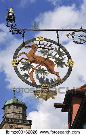 "Hanging sign of the guesthouse and former Brauner Hirsch brewery, 18th century, in front of the tower of the Catholic Parish Church of St. George, Dinkelsbuhl, Middle Franconia, Bavaria, Germany, Europe" View Large Photo Image Stock Photograph - "Hanging sign of the guesthouse and former Brauner Hirsch brewery, 18th century, in front of the tower of the Catholic Parish Church of St. George, Dinkelsbuhl, Middle Franconia, Bavaria, Germany, Europe". Fotosearch