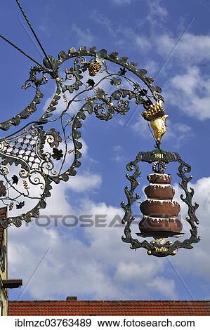 Stock Photo - "Hanging sign with a """"Baumkuchen"""" or tree cake from the Kaffeehaus Trexler coffee house, Dinkelsbuhl, Middle Franconia, Bavaria, Germany, Europe". Fotosearch
