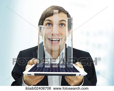Stock Photograph - "Happy businessman holding an iPad with a glassy bar chart, symbolic image for economy, growth, profit, economic recovery". Fotosearch