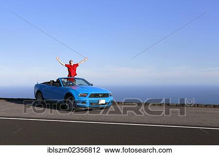 "Happy man in a sky-blue Ford Mustang convertible by the sea, Big Island, Hawaii, USA" View Large Photo Image Stock Image - "Happy man in a sky-blue Ford Mustang convertible by the sea, Big Island, Hawaii, USA". Fotosearch