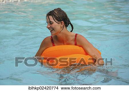 Happy young woman, 18 years old, with a floating tire in a swimming pool, French Riviera, France, Europe View Large Photo Image Picture - Happy young woman, 18 years old, with a floating tire in a swimming pool, French Riviera, France, Europe. Fotosearch