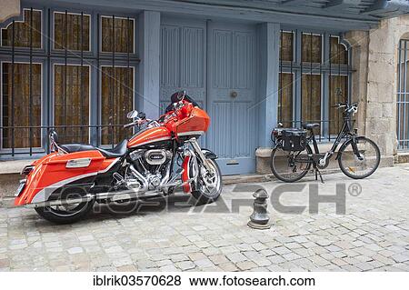 Stock Photo - "Harley Davidson motorcycle and a bicycle with saddlebags, Quimper, Departement Finistere, Brittany, France, Europe". Fotosearch