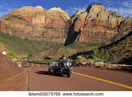 "Harley Davidson motorcycle on the red road of Zion Park Boulevard - Mount Carmel U. S. Highway 9, in front of the Towers of the Virgin mountain range, East Temple, Zion and Pine Creek Canyon, Zion National Park, Utah, United States, North America" View Large Photo Image Stock Photo - "Harley Davidson motorcycle on the red road of Zion Park Boulevard - Mount Carmel U. S. Highway 9, in front of the Towers of the Virgin mountain range, East Temple, Zion and Pine Creek Canyon, Zion National Park, Utah, United States, North America". Fotosearch
